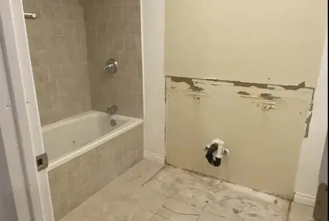 Bathroom demolition with vanity and drywall removed, ready for remodel