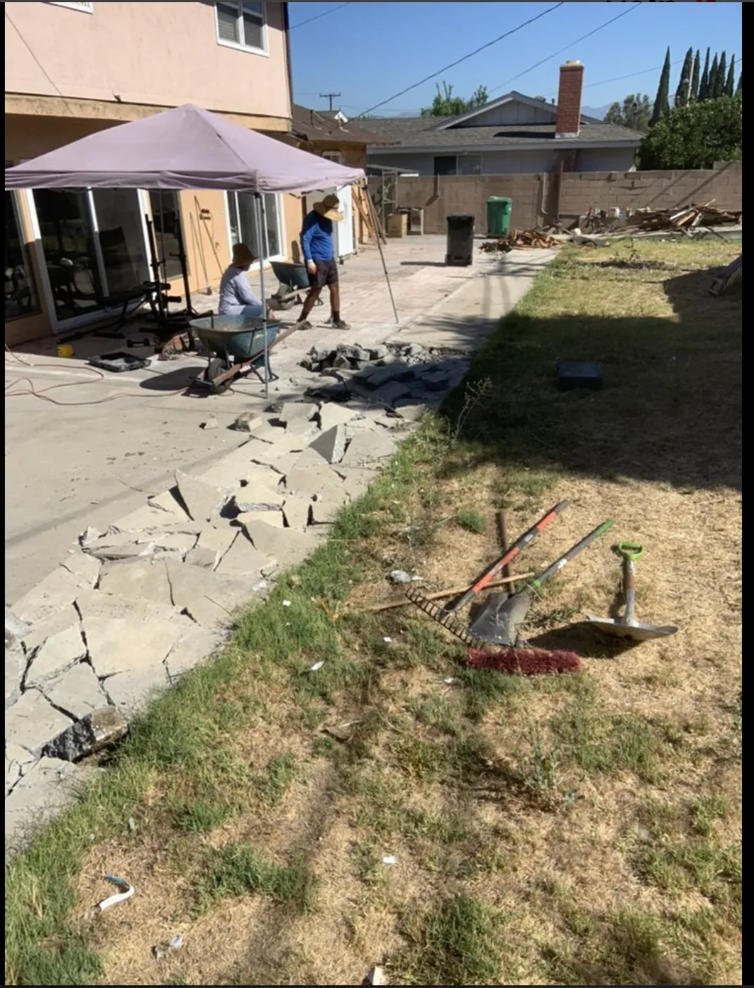 Concrete patio demolition and removal in a residential backyard