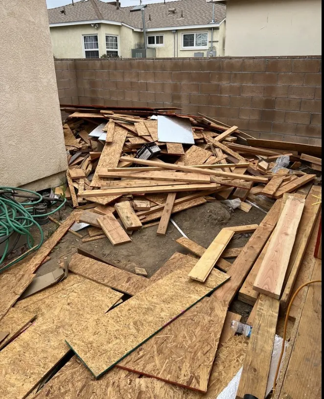 Pile of construction debris and lumber cleared from a backyard job site