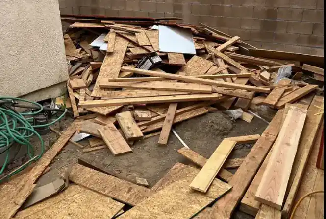 Pile of construction debris and lumber cleared from a backyard job site