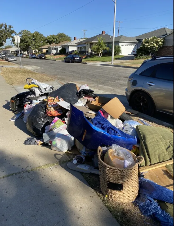 Large residential street pile of bagged trash and bulky items ready for hauling