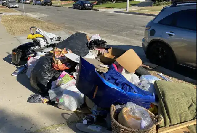 Large residential street pile of bagged trash and bulky items ready for hauling